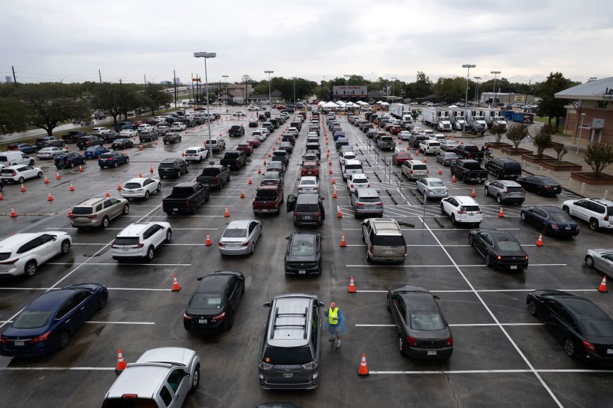 An aerial view shows lines of vehicles as people arrive to receive food assistance at a turkey distribution intended for federal workers and Supplemental Nutrition Assistance Program (SNAP) recipients organized by the Houston Food Bank in Houston, Texas, on November 22, 2025.