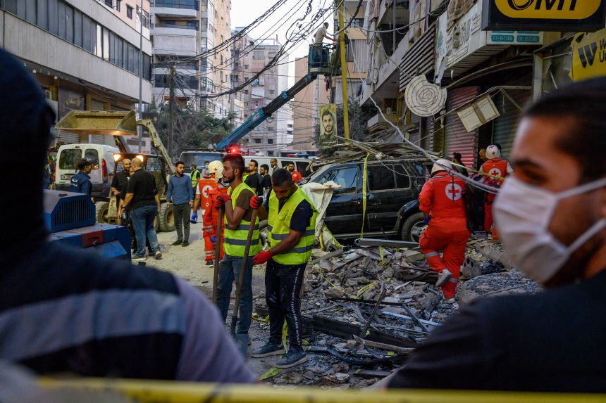 Hezbollah members and Lebanese Army soldiers clear debris after a deadly Israeli attack on an apartment building in Beirut, on November 23.