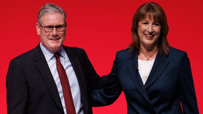 Keir Starmer and Rachel Reeves smiling and standing together on stage against a red background at the Labour Party conference.