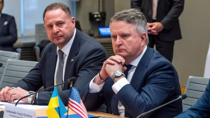 Sergiy Kyslytsya sits at a conference table with Andriy Yermak, with Ukrainian and US flags visible in front of them.