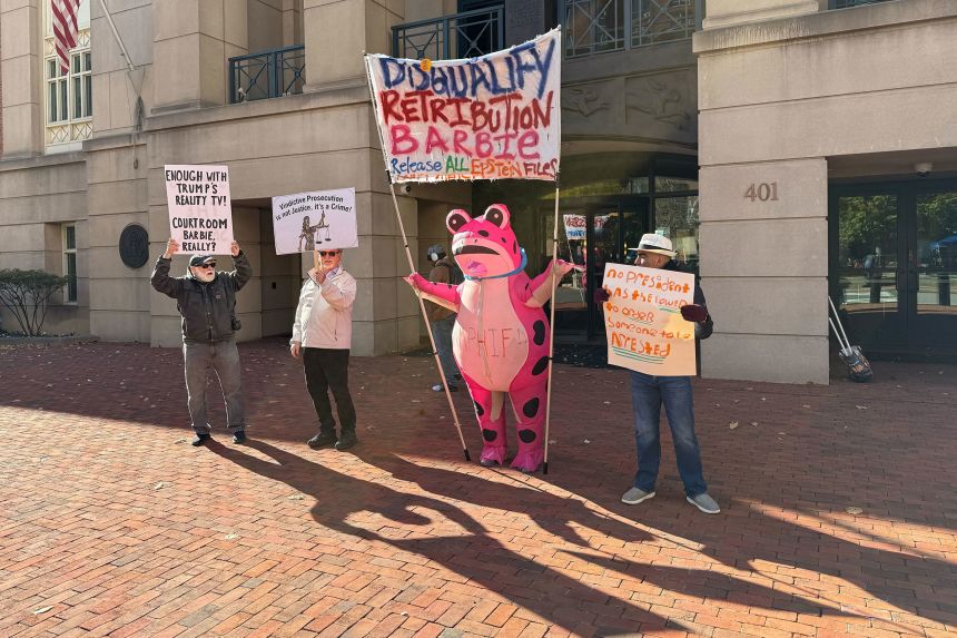 Protesters hold signs outside of the Albert V. Bryan United States Courthouse in Alexandria, Virginia, on November 13, during a hearing on US Attorney Lindsey Halligan’s authority.