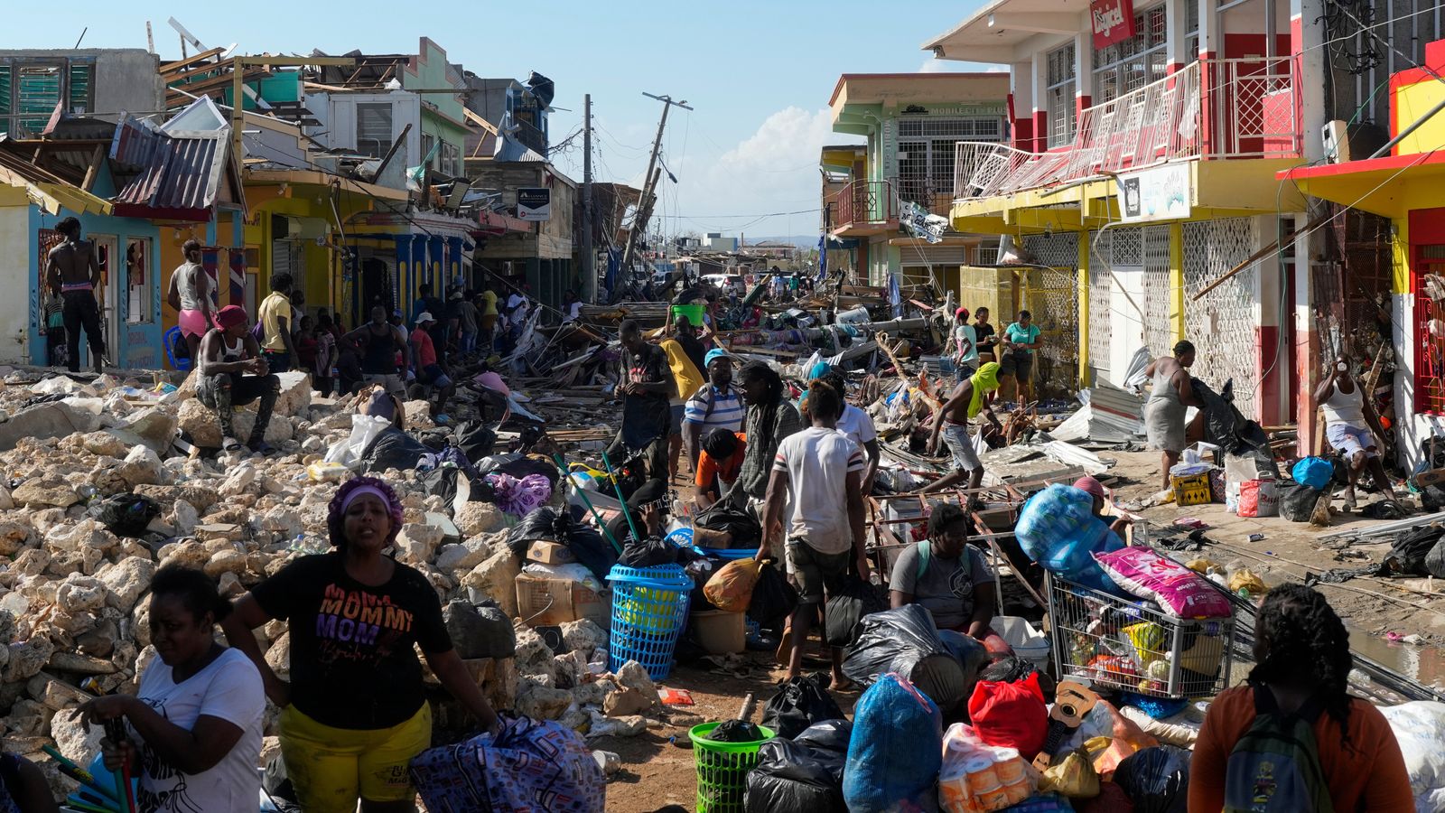 All that is left: Residents gather amid the debris of their homes and town. Pic: Associated Press
