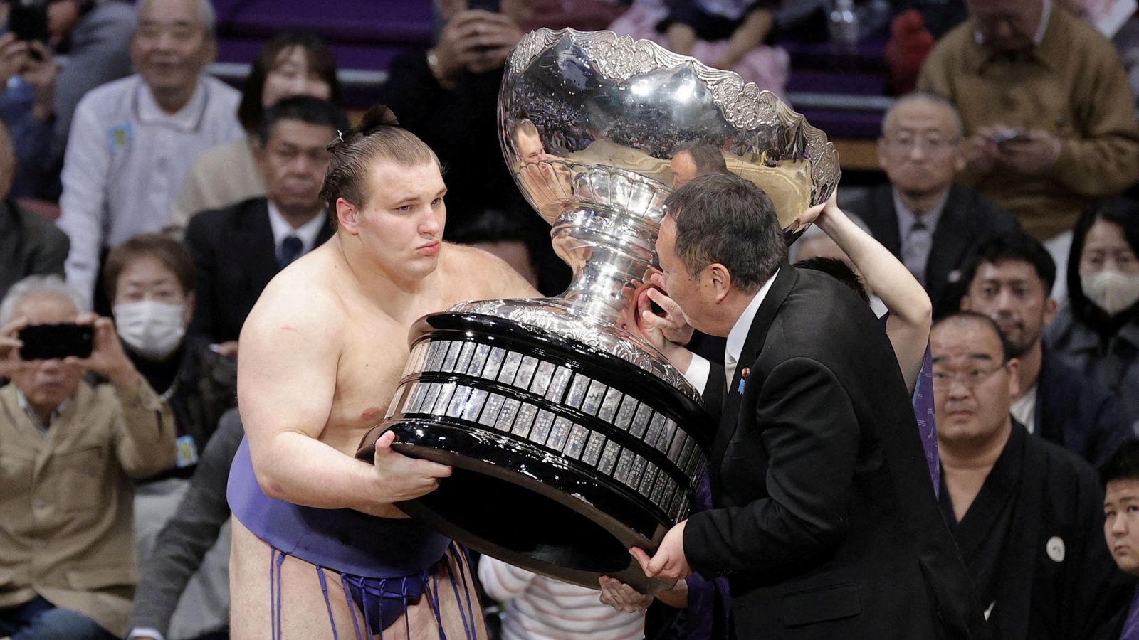 Ukrainian sumo wrestler Danylo Yavhusishyn, 21, receives the Prime Minister's Cup. Pic:  Kyodo/via Reuters