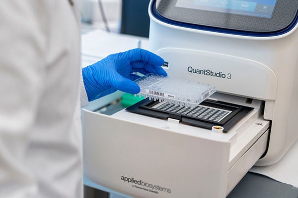 Lab tech placing blood for diagnostics