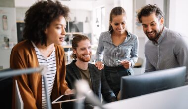 Investors gather around a computer in an office.