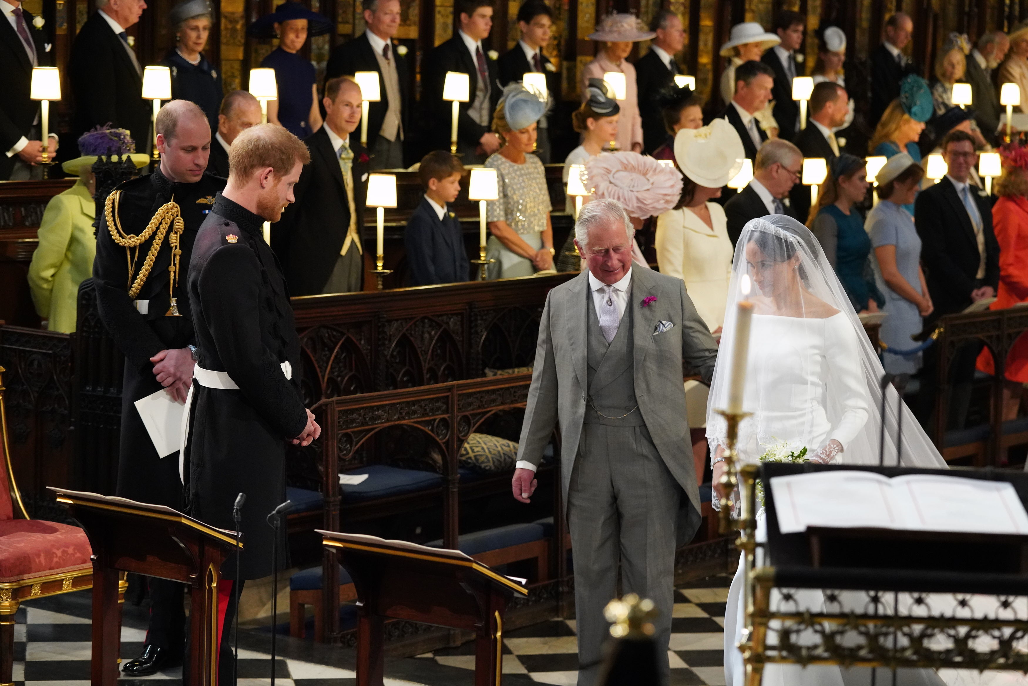 Prince Harry looking at Meghan Markle as she arrives at the altar with the Prince of Wales for their wedding at Windsor Castle.