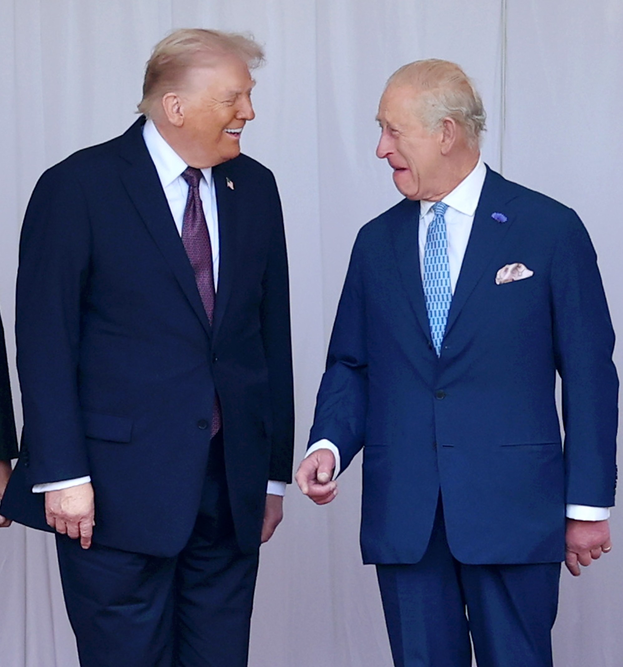 Donald Trump and King Charles III smiling and facing each other.