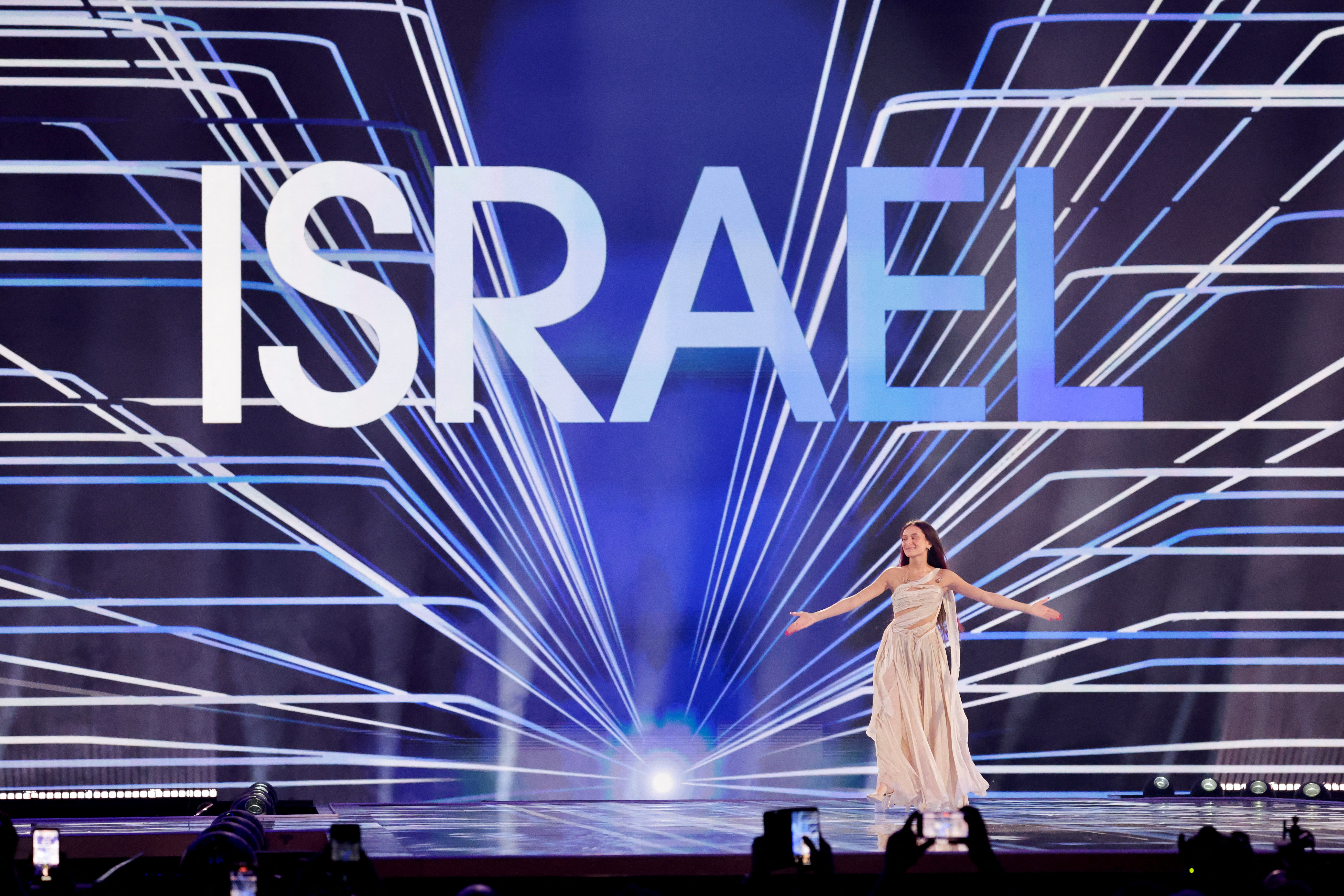 Eden Golan, representing Israel, stands on stage in a light dress during the 2024 Eurovision Song Contest rehearsals.