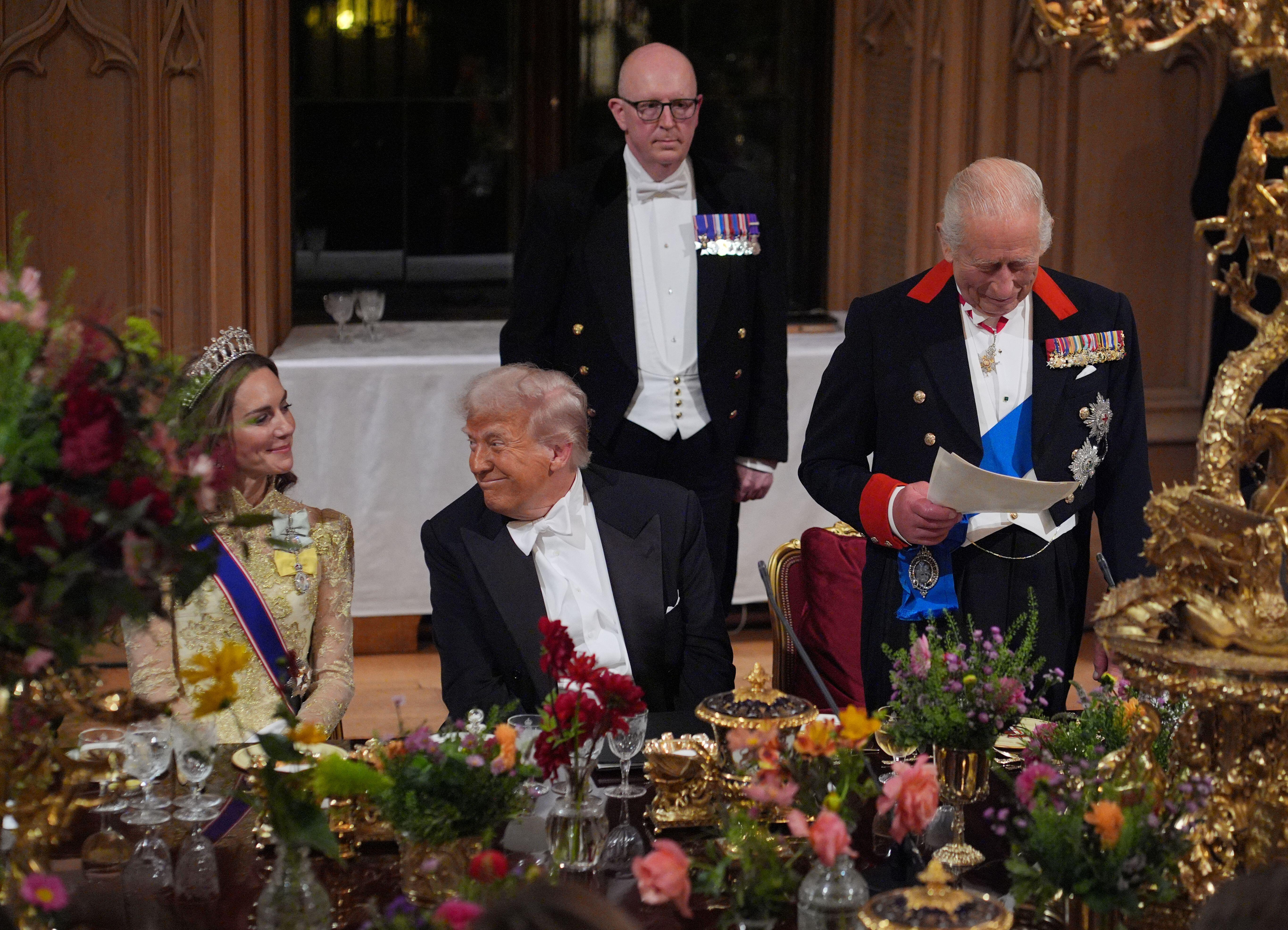 King Charles III delivering a speech at a state banquet at Windsor Castle, with US President Donald Trump and the Princess of Wales listening.