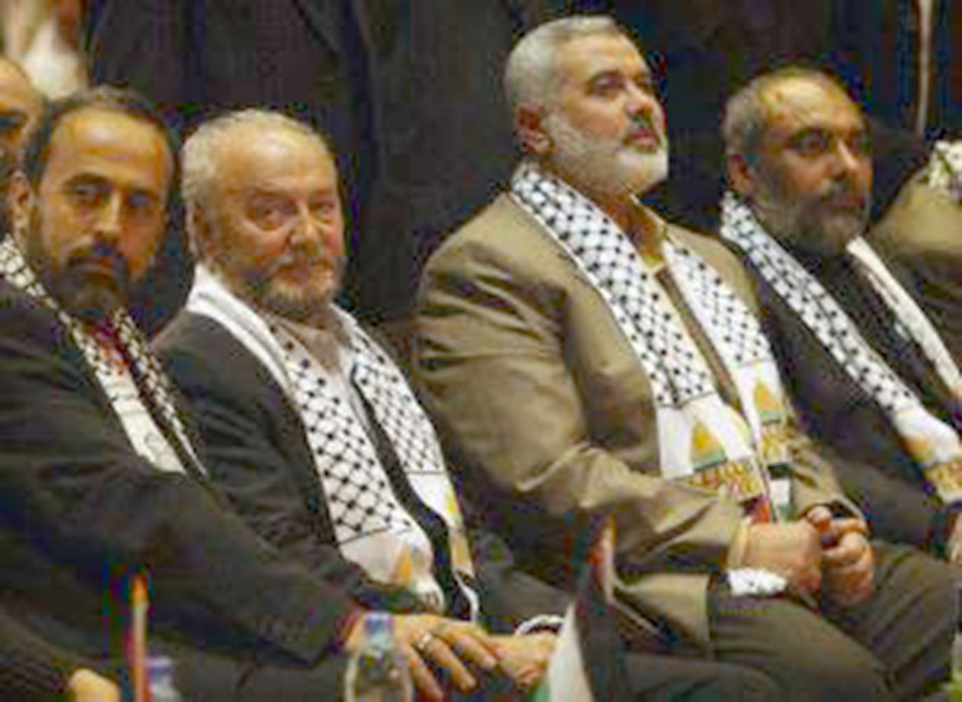Zaher Birawi, George Galloway, and Ismail Haniyeh are seated, all wearing keffiyeh scarves.