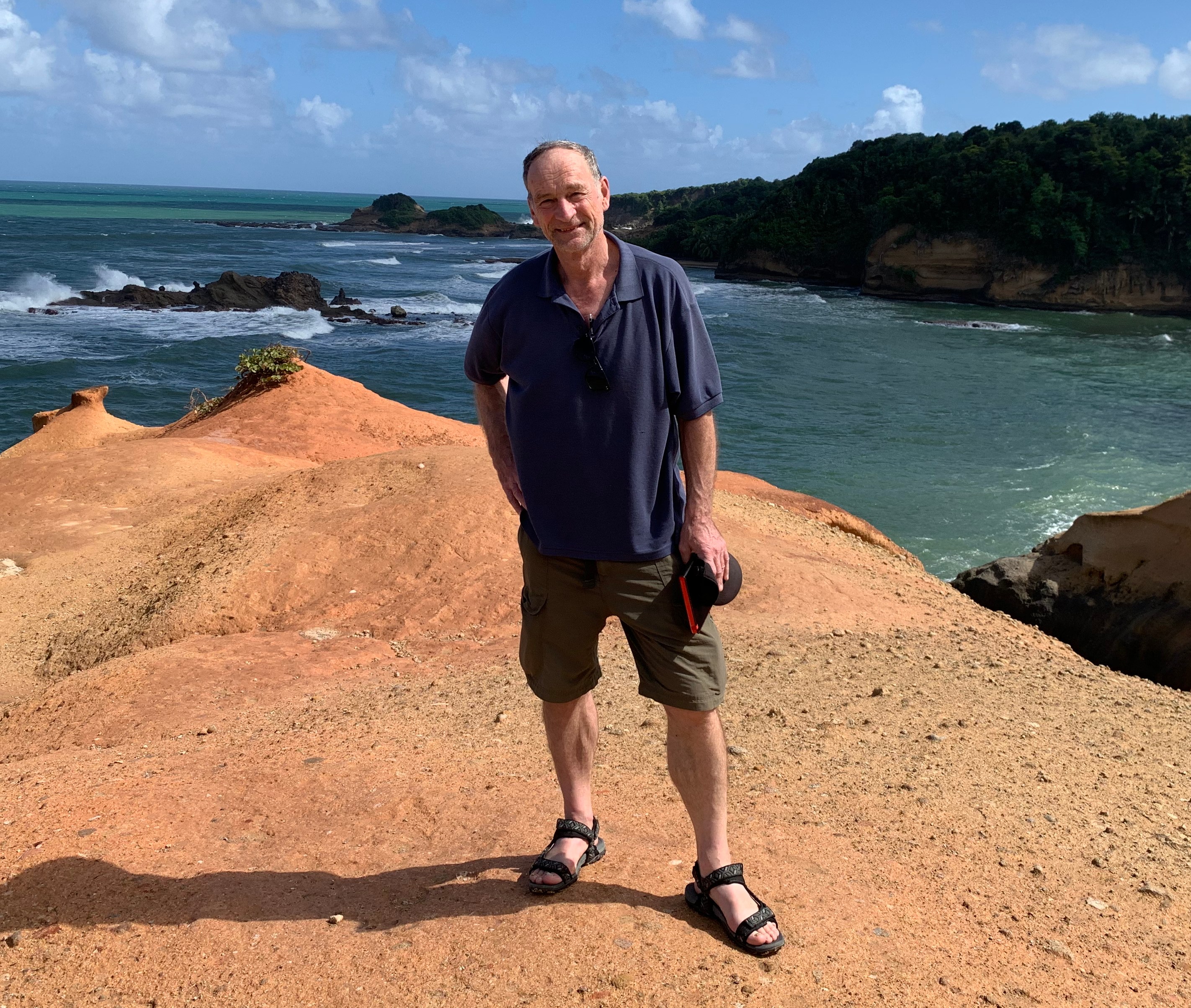Andrew Eames standing on a bluff overlooking the ocean in Dominica.