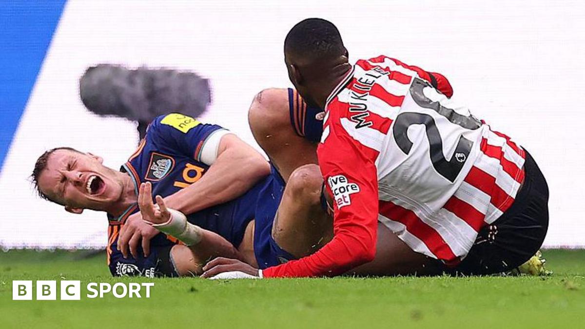 Dan Burn holds his rib after a tackle from Nordi Mukiele during Newcastle United's game against Sunderland at the Stadium of Light on 14 December, 2025