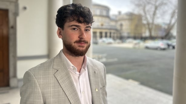 Jonathan Monroe stands in an outdoor area.
