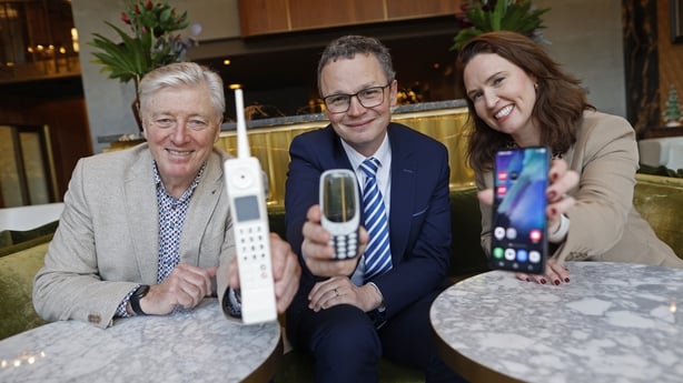 Photo shows three people holding mobile phones