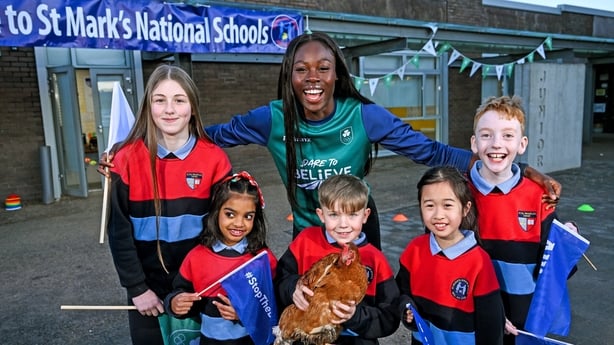 12 December 2025; Team Ireland Olympian Rhasidat Adeleke pictured at St. Mark's Senior School in Dublin this morning with pupils, from left, Lucy Balfe, age 11, Ridhanya Jaganathan, age 8, Leo Reddin, age 8, holding Rhasidat the chicken, Katherine Nguyen, age 8 and AJ Carney, age 12, as part of the 