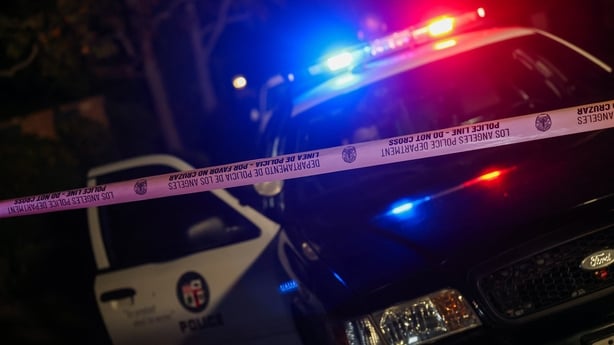 A Los Angeles Police Department patrol car behind police tape blocking access to a house in Los Angeles.