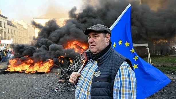 A farmer carrying a flag of the European Union (EU) during a protest against the Mercosur deal in Brussels,