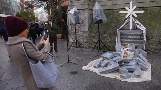 People viewing the Gaza Solidarity Nativity Scene showing baby Jesus lying in rubble on Suffolk Street, Dublin