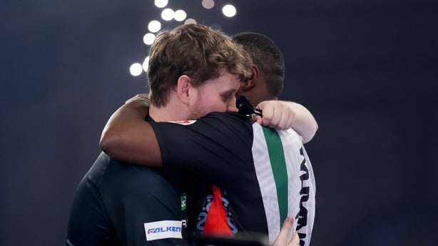 Winner Netherland's Kevin Doets embraces Kenya's David Munyua after Round 2 match at 2026 World Darts Championship