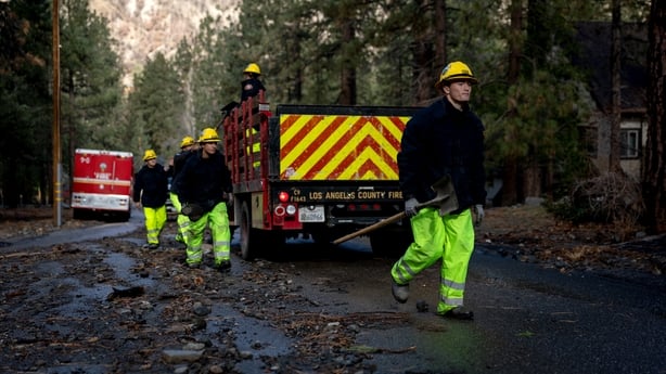Los Angeles County firefighters dig a pathway for a resident in Wrightwood, California