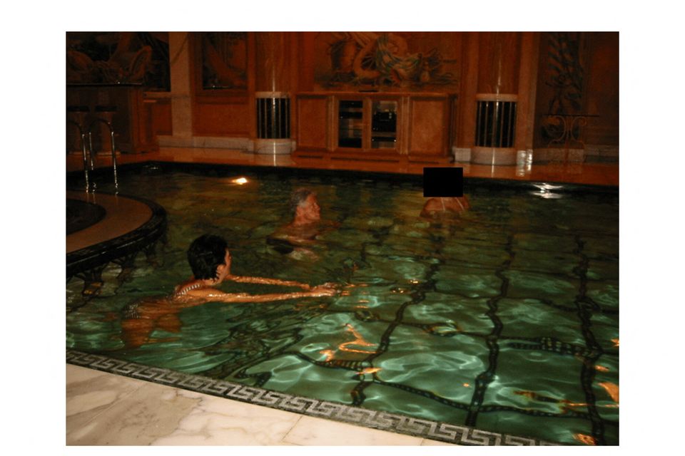 Former U.S. President Bill Clinton swims in a pool.