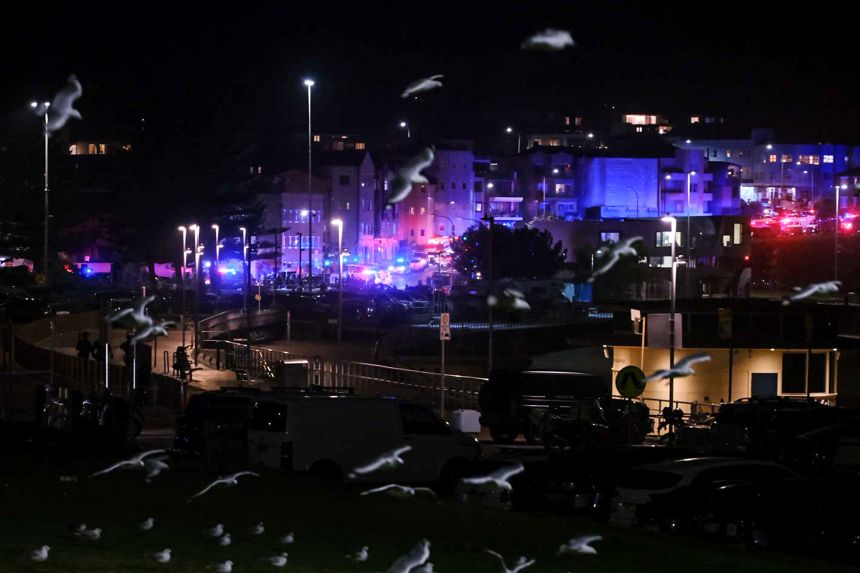 Birds fly over police cordons at at the scene of a mass shooting at Bondi Beach in on December 14, 2025 in Sydney, Australia.