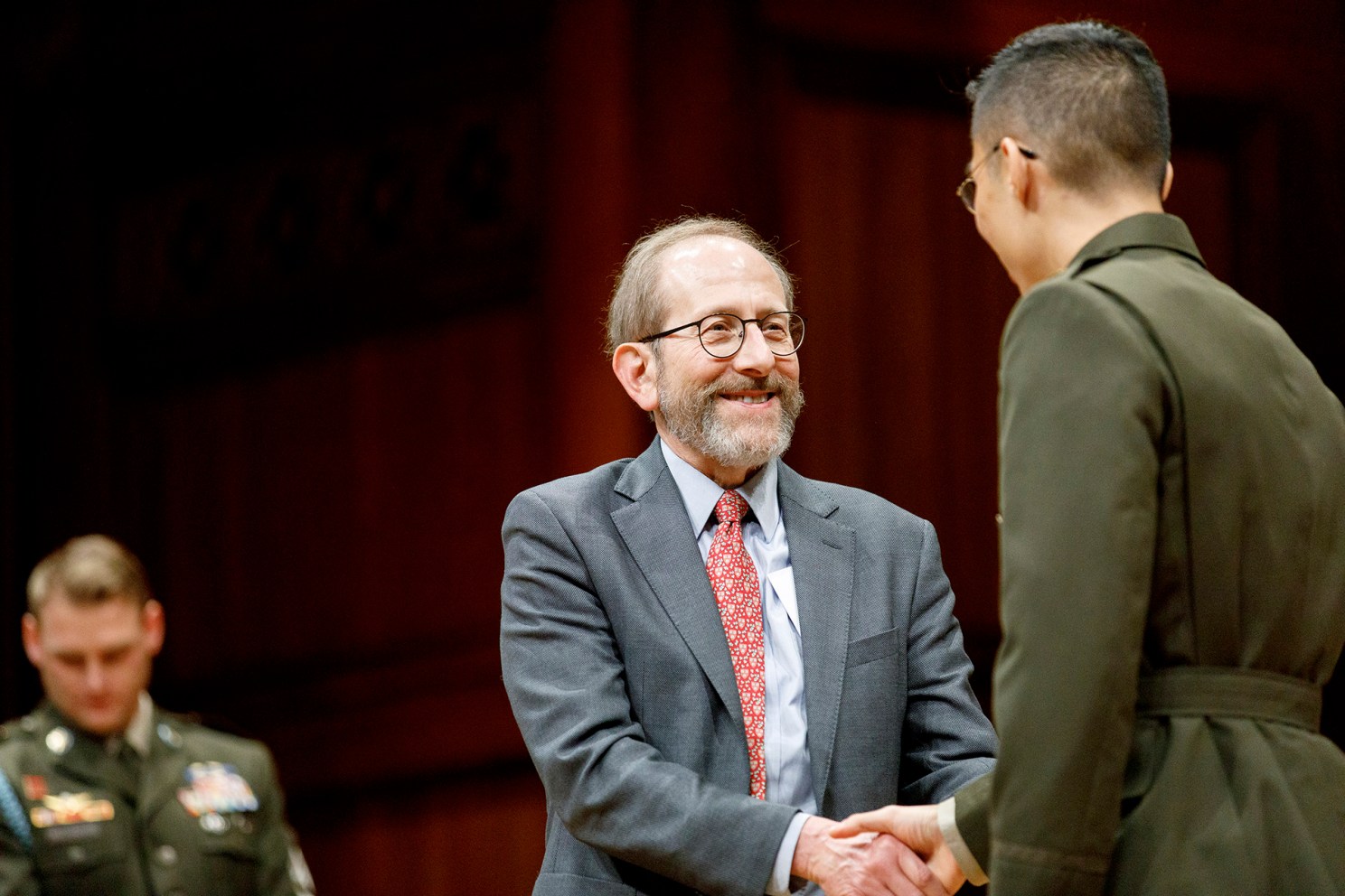 Alan Garber shakes Andrew Lim's hand at 2025 ROTC ceremony.