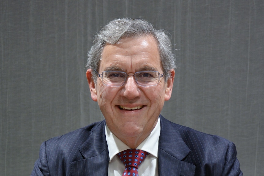 Picture of ASIC chair Joseph Longo in suit and tie smiling.