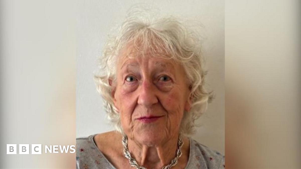A police car stationed outside a semi-detached 1930s-style house on Kingsbury Avenue. There is police tape across the drive and a blue car parked on it.