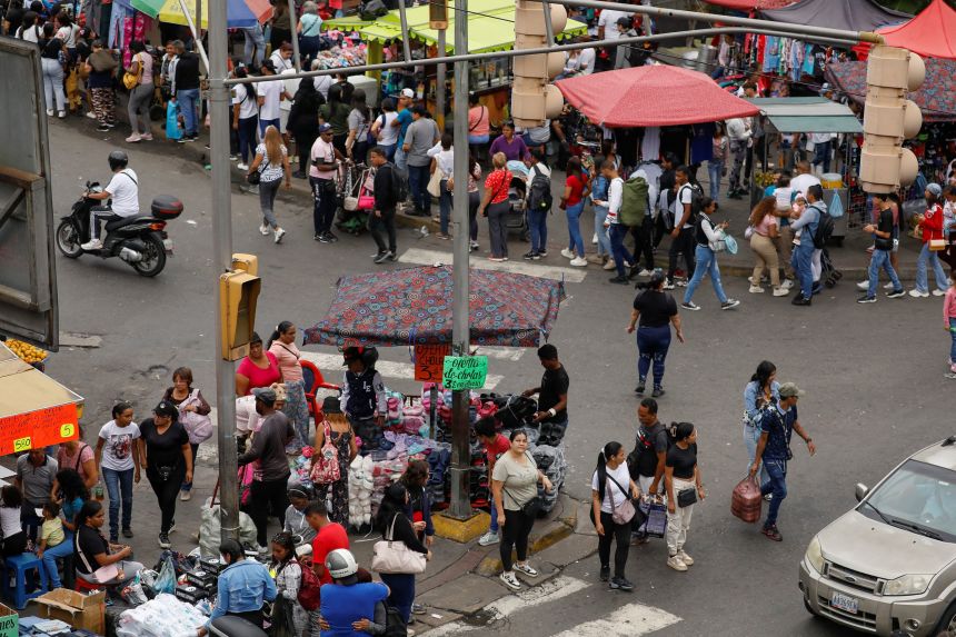People shop at a market in Caracas on November 29, 2025.