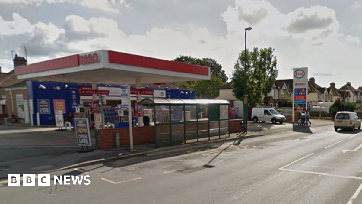 An Esso garage is by the side of a road with residential homes in a row behind the garage from a Google streetview screenshot