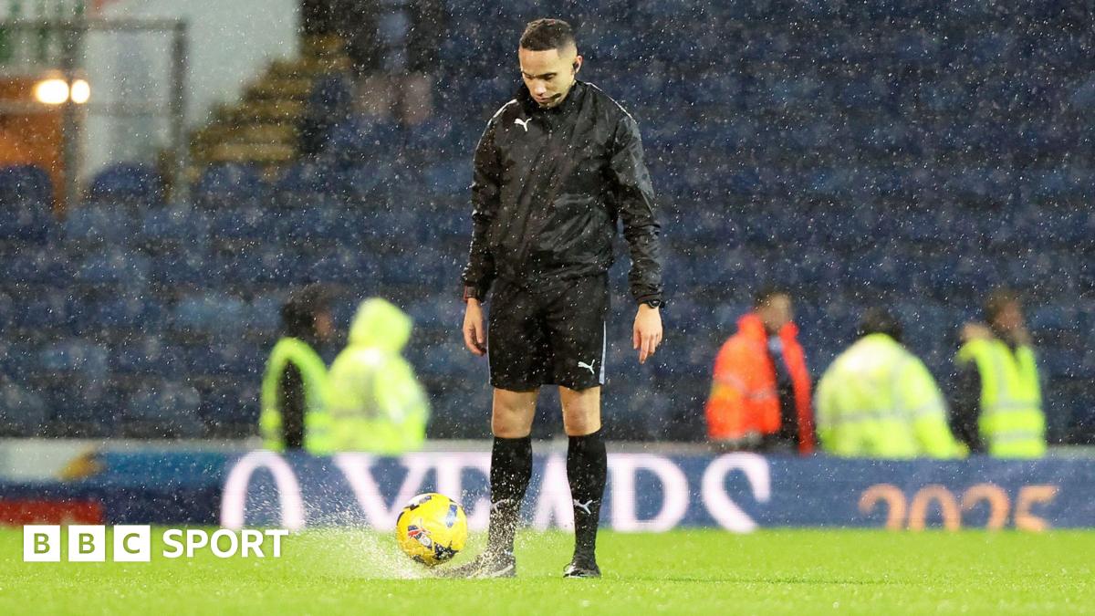 Referee Ruebyn Ricardo tries the bounce test and abandons the game during Blackburn Rovers' Championship fixture with Sheffield Wednesday