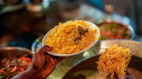 Maroof Culmen A man serving a plate of biryani in Lucknow