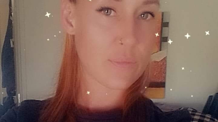 A woman in an Adidas shirt with red hair