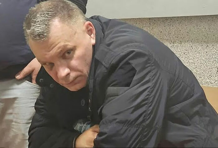 Man in black jacket looking serious indoors, related to crypto scammer case in Dubai mall investigation.