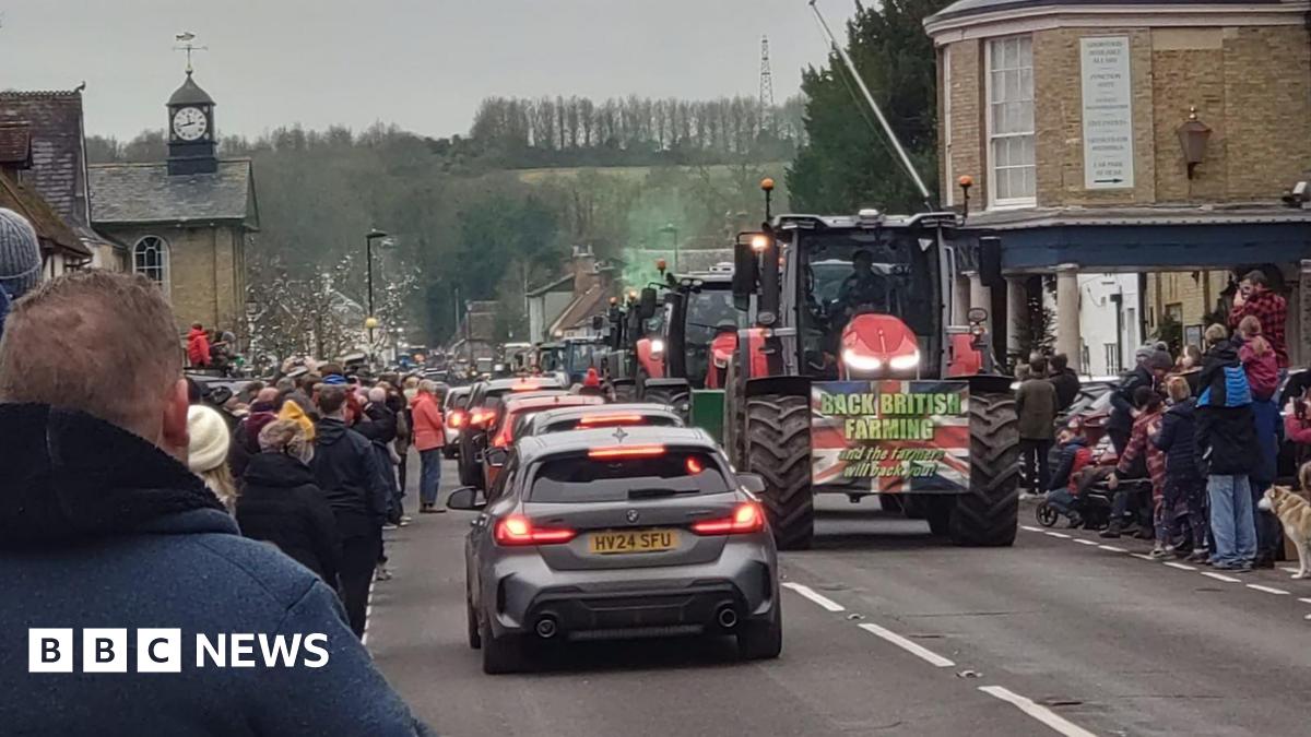 Cars and tractors travelling on a village road