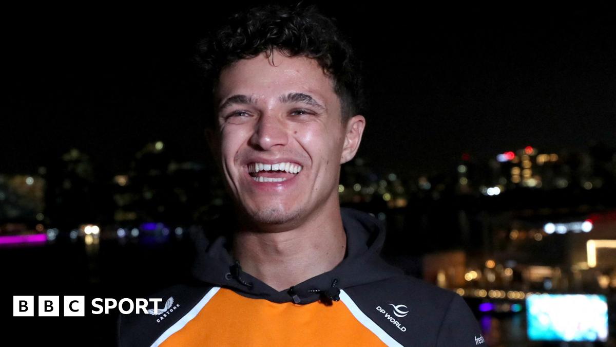 A smiling Lando Norris is interviewed with the background of a night sky in Abu Dhabi the day after winning the Formula 1 drivers' championship