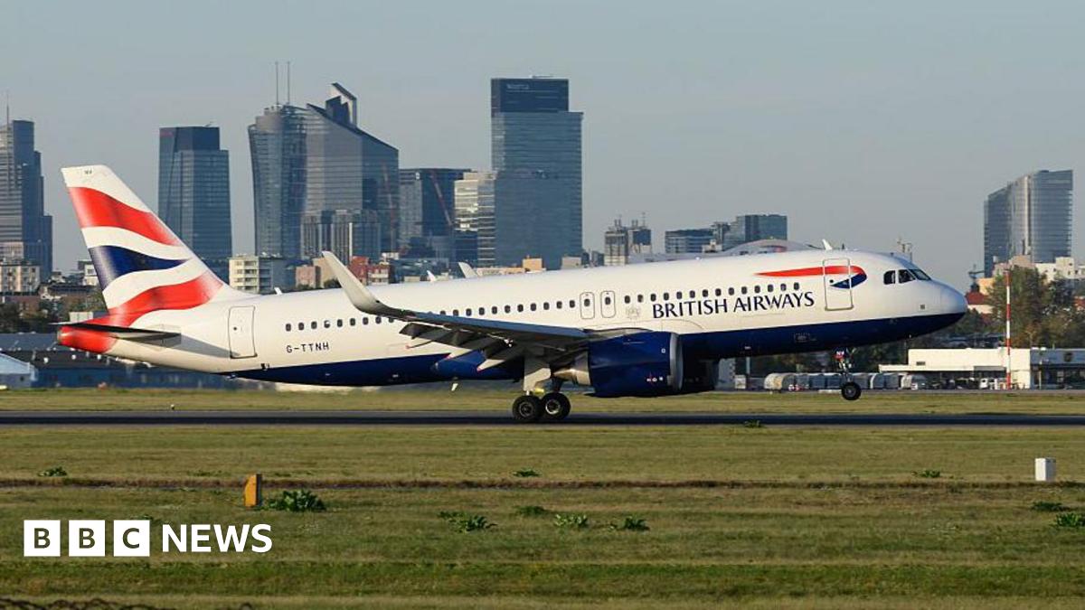 A British Airways Airbus A320 aircraft lands with Warsaw's skyline in the background at the Warsaw Chopin International Airport