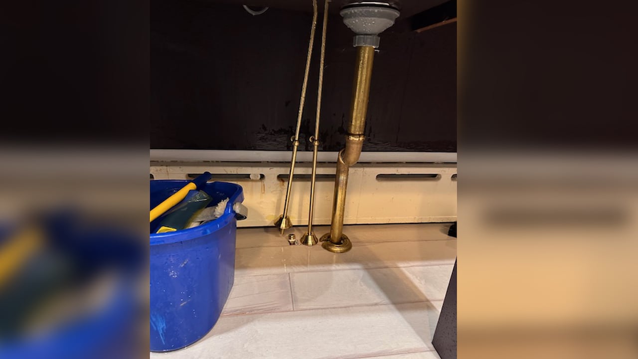 A photo of a kitchen plumbing line that appears detached.