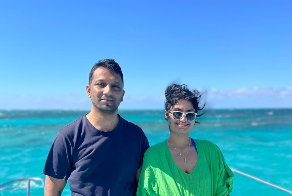 A man and woman standing with an ocean backdrop