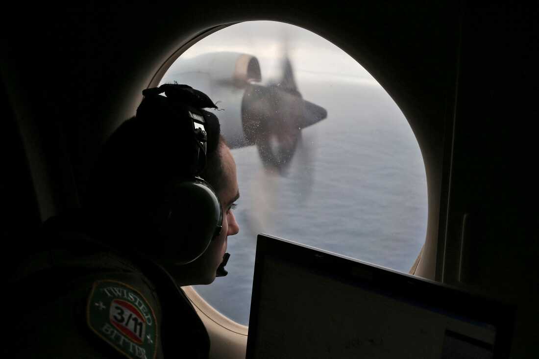 FILE - Flight officer Rayan Gharazeddine scans the water in the southern Indian Ocean off Australia from a Royal Australian Air Force AP-3C Orion during a search for the missing Malaysia Airlines Flight MH370 on March 22, 2014.
