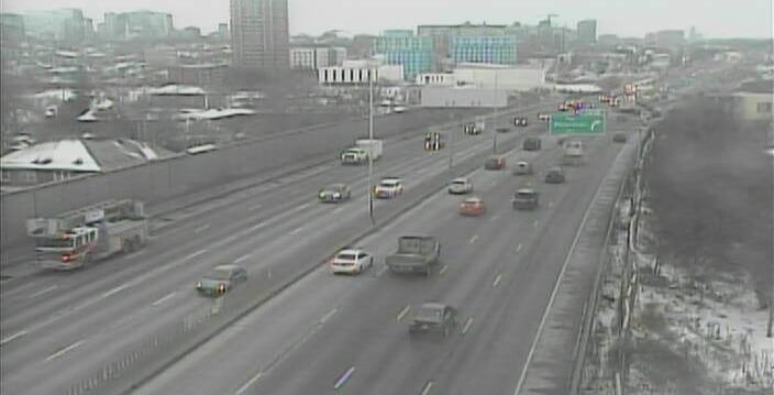 A traffic camera view of a downtown, eight-lane highway on a winter morning