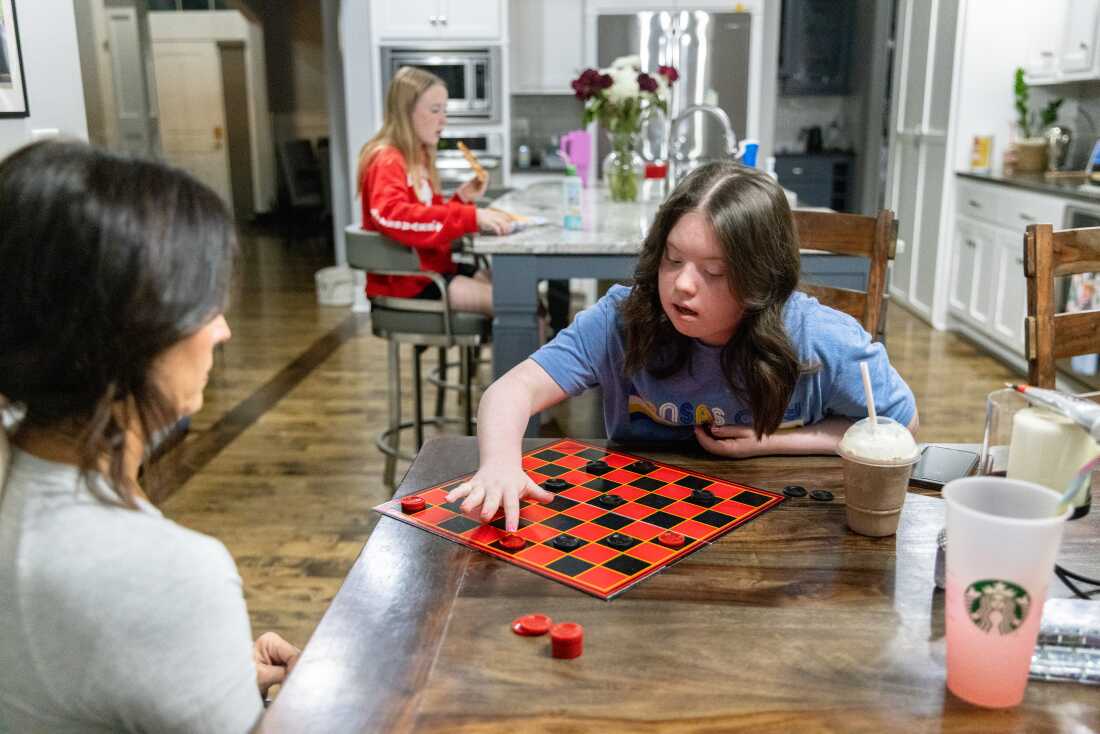 Maggie Heilman and her daughter Brooklynn play checkers. Brooklynn loves games, painting her nails and listening to Taylor Swift.