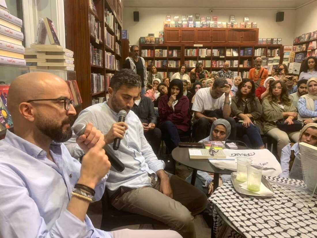 Bassem Khandaqji (left) gives a book talk in Cairo after being freed from Israeli prison.