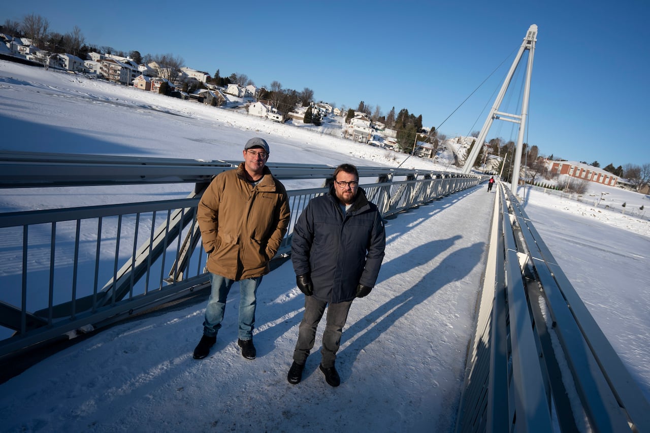 Two men on a bridge.
