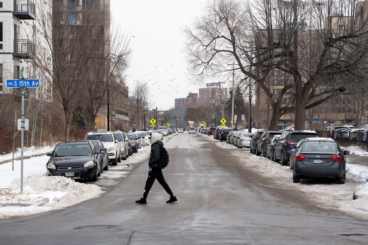 A man crosses a snowy street