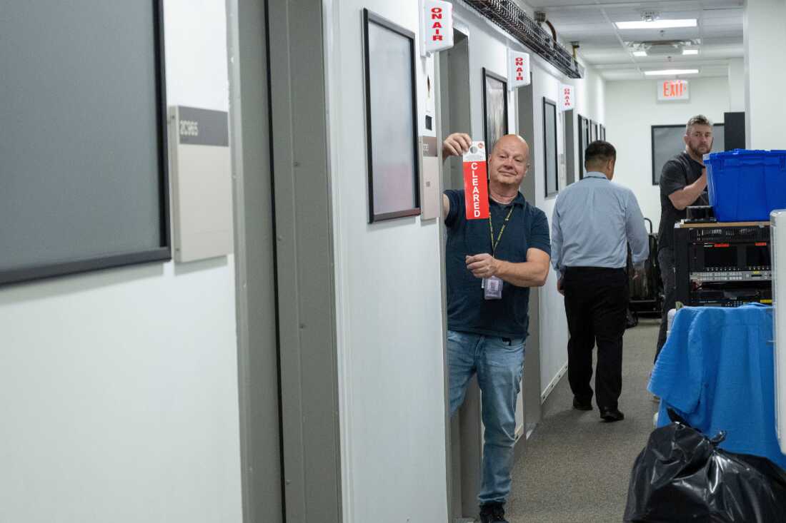 Neil Wallace signals that the Fox News staff has cleared the contents of their broadcast booth in the press area of the Pentagon on Oct. 15 in Washington.
