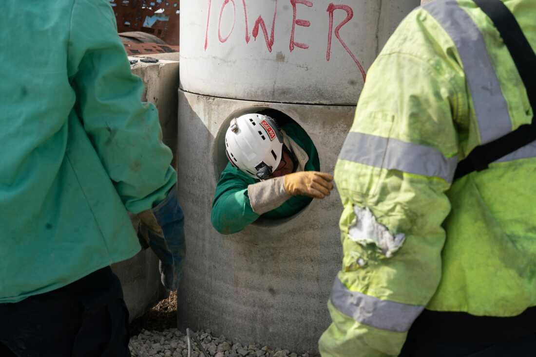  A search and rescue expert climbs out of a concrete tower.