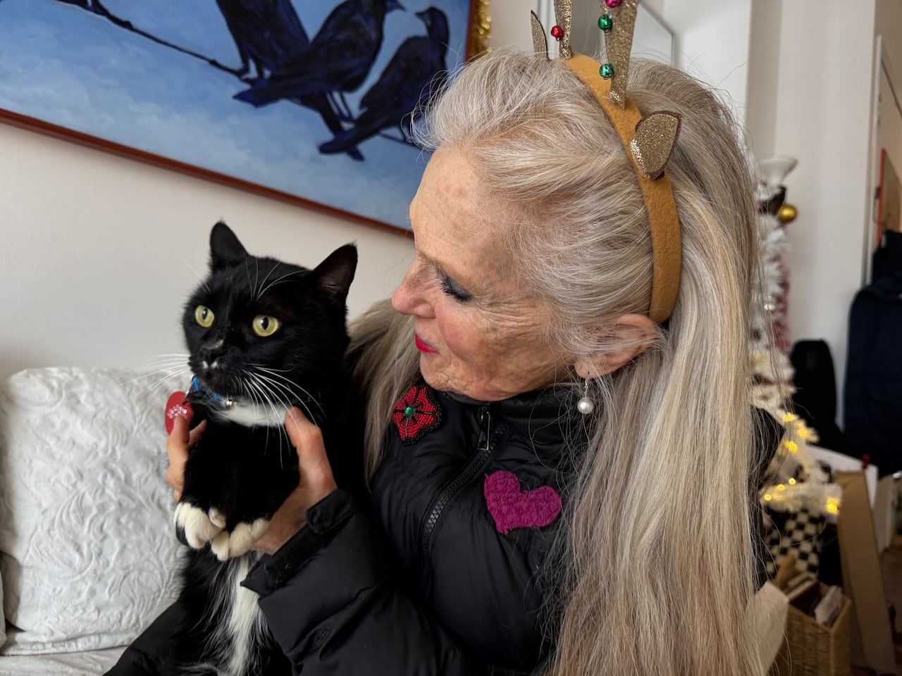 A white woman holds a black cat.