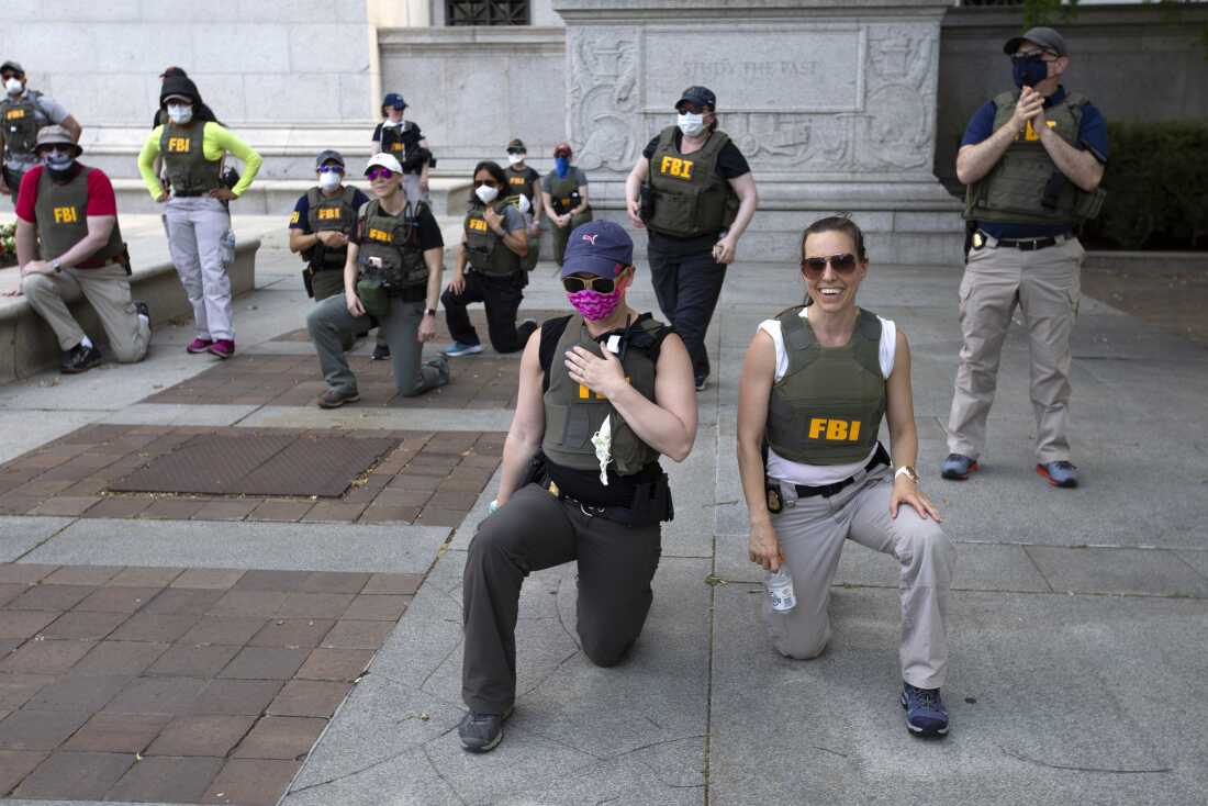 FBI officers are seen here taking a knee as demonstrators marched in June 2020, in Washington, D.C., during a protest over the death of George Floyd, a Black man who died after a police officer kneeled on his neck for several minutes.